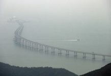 This general view shows a police boat patrolling waters around a section of the Hong Kong-Zhuhai-Macau Bridge (HKZM) in Hong Kong on October 23, 2018. - China's President Xi Jinping officially opened the world's longest sea bridge connecting Hong Kong, Macau and mainland China on October 23, at a time when Beijing is tightening its grip on its semi-autonomous territories.