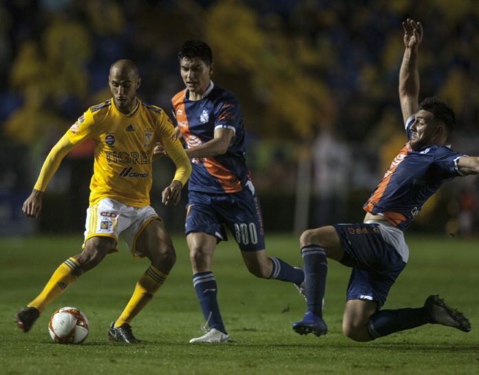 Guido Pizarro (L) of Tigres vies for the ball with Vladimir Lorona (C) and Luis Robles of Puebla, during the Mexican Apertura 2018 tournament football match at the Universitario stadium in Monterrey, Mexico, on November 10, 2018.